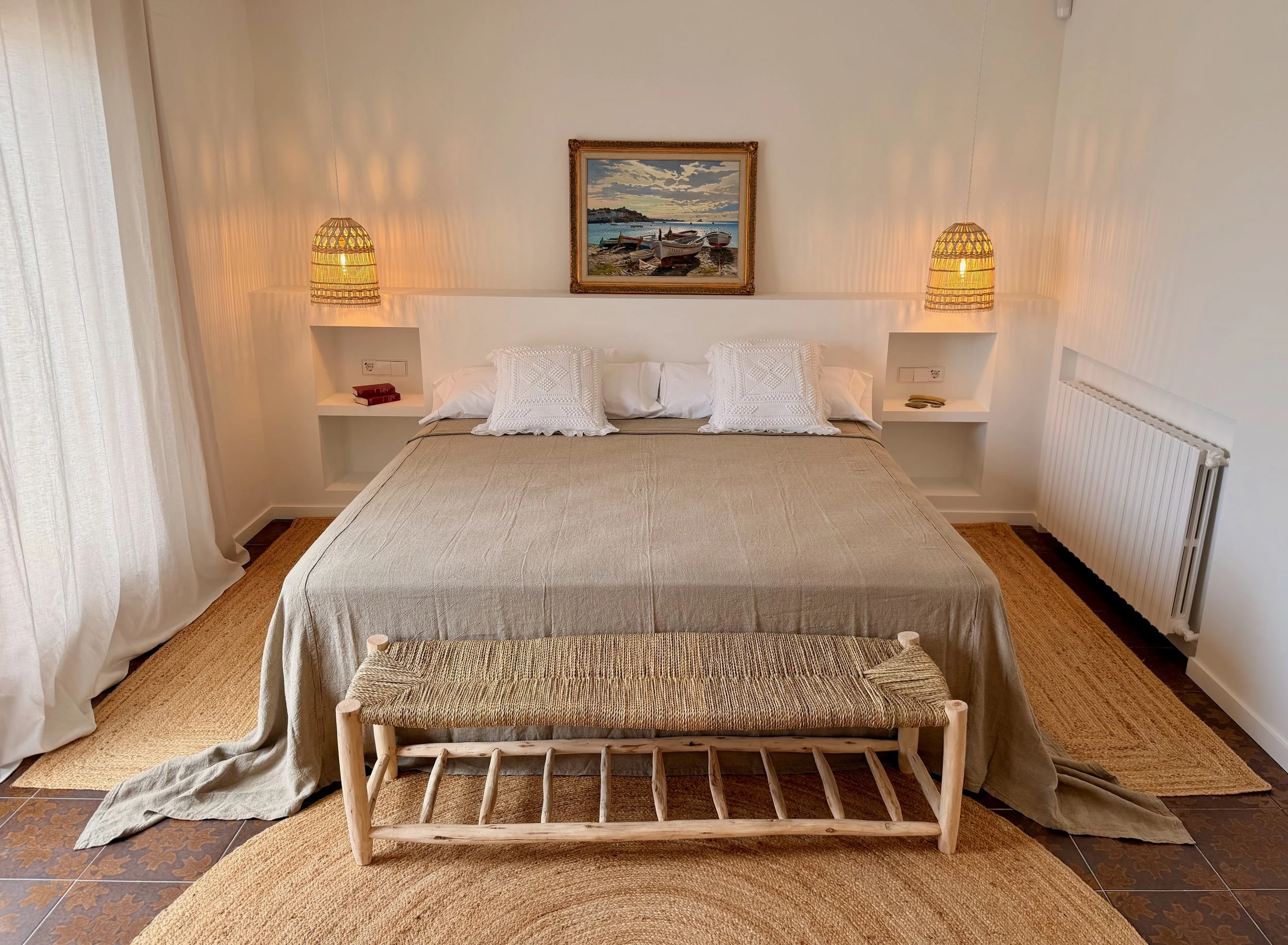 Detalle de banco y alfombra de esparto en la habitación exclusiva y con mucho encanto en la casa de alquiler  Ca la Nuri - Cadaqués. 