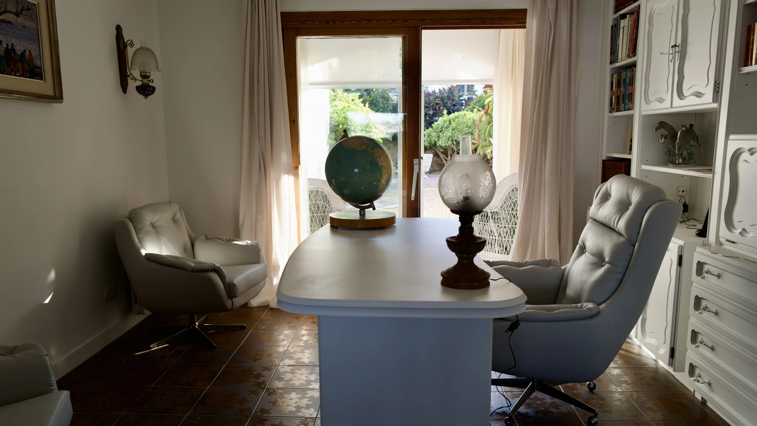 Despatxo en la Casa de alquiler Ca la Nuri - Cadaqués. Un espacio luminoso, cómodo, con acceso a la sala de estar - comedor, y a una pequeña galería. Con vistas al jardín interior. Un espacio donde trabajar relajado y con un ambiente cálido, en la pl