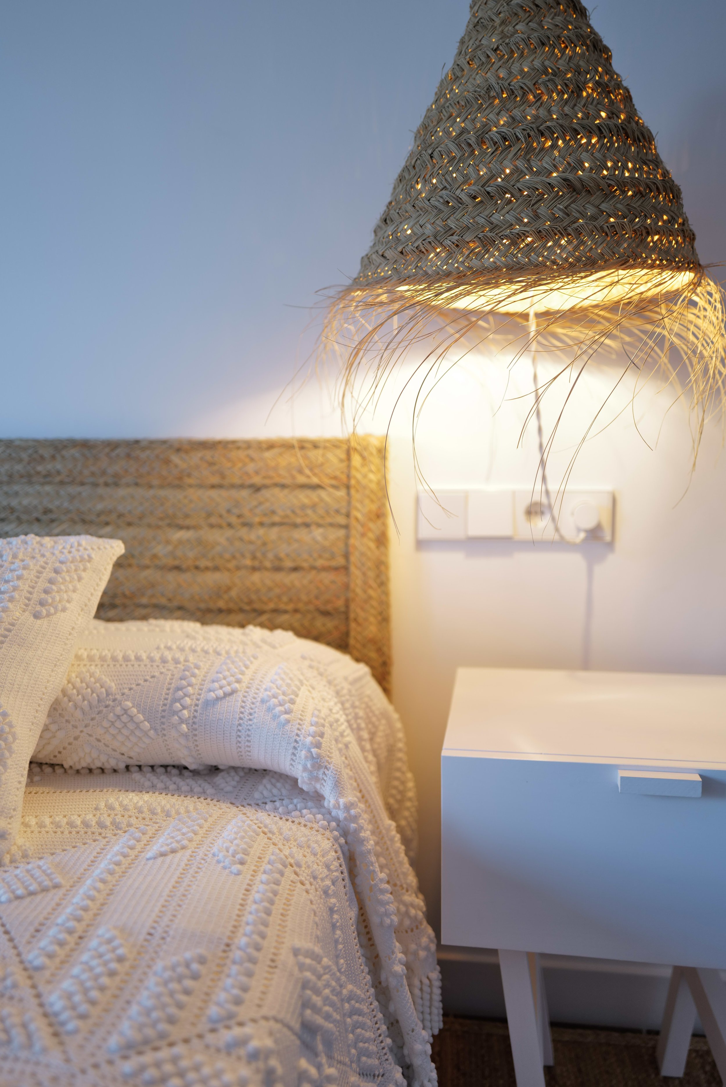 Habitación en la casa de alquiler Ca la Nuri Cadaqués. Habitación doble con terraza y vistas al mar. Tiene una terraza con vistas al mar. Decorada con cubrecama de ganchillo hecho a mano y lámparas de esparto. 