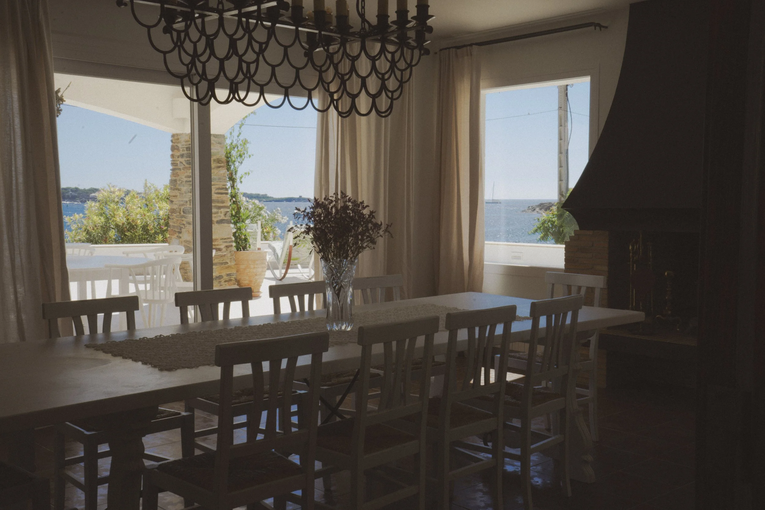 Gran mesa en el comedor  con espectaculares  vistas al mar de la exclusiva casa de alquiler Ca la Nuri en la playa del Llané en el pueblo de Cadaqués.