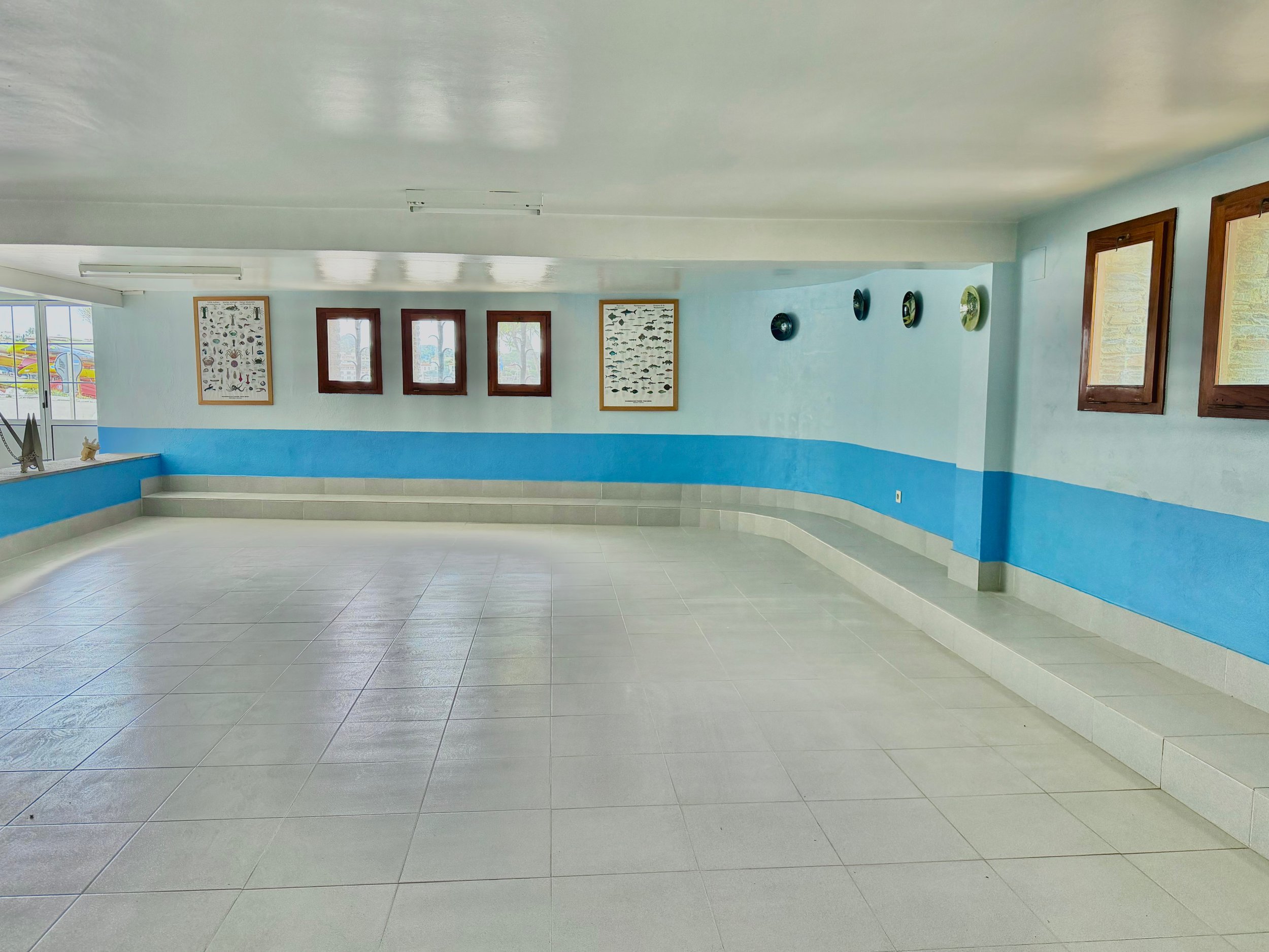 Garaje con mucho espacio para aparcar hasta 5 coches, almacén, taller de bricolaje, y elementos de decoración marinos.