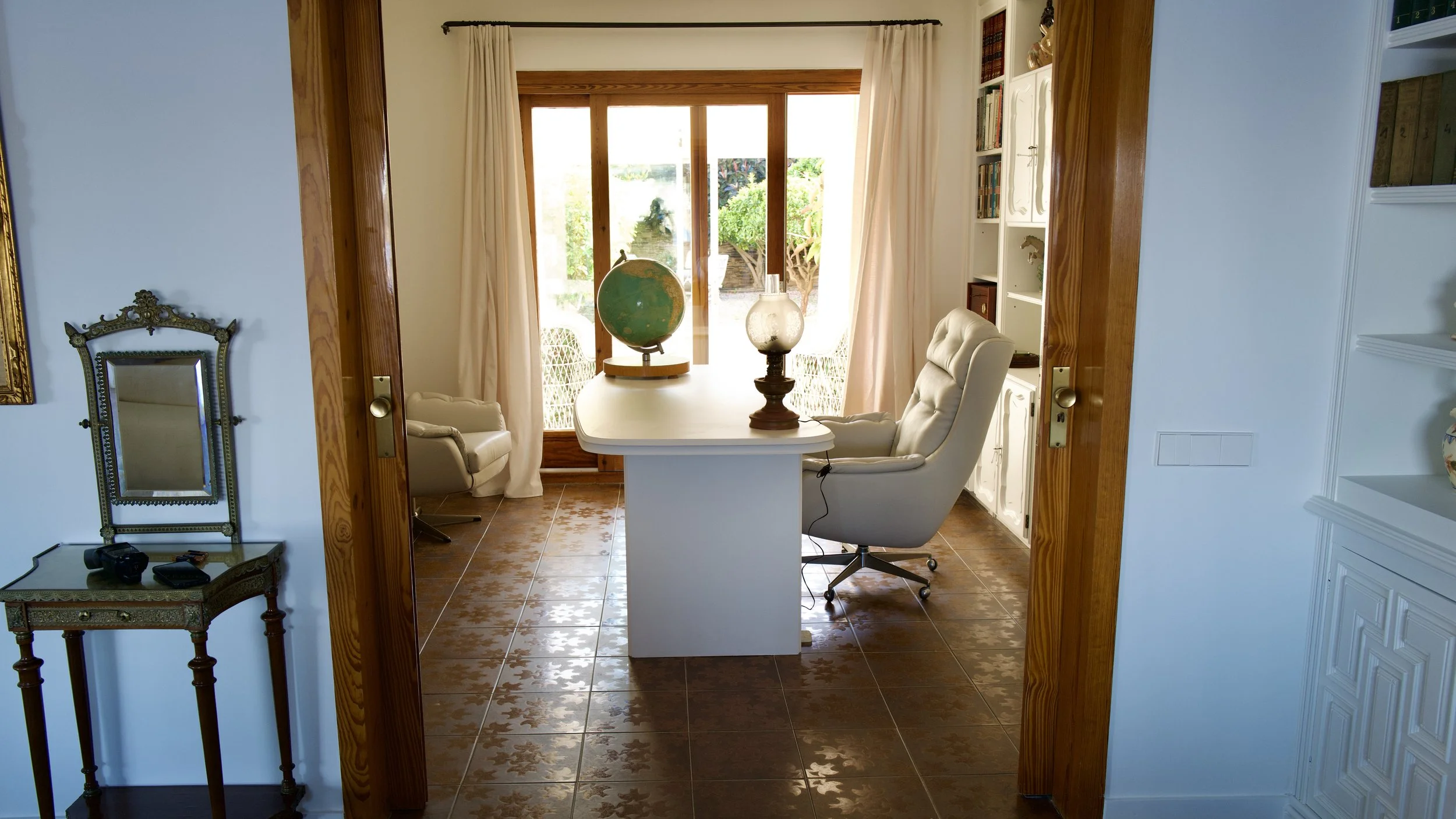 Despatxo en la Casa de alquiler Ca la Nuri - Cadaqués. Un espacio luminoso, cómodo, con acceso a la sala de estar - comedor, y a una pequeña galería. Con vistas al jardín interior. Un espacio donde trabajar relajado y con un ambiente cálido, en la pl