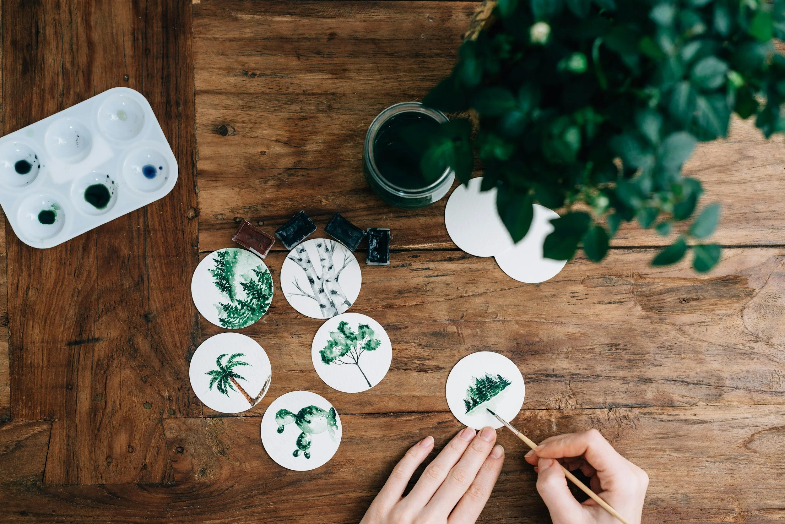 Hand painting watercolor plants onto small circles