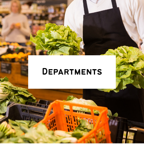 A person in a grocery store holding leafy greens with a