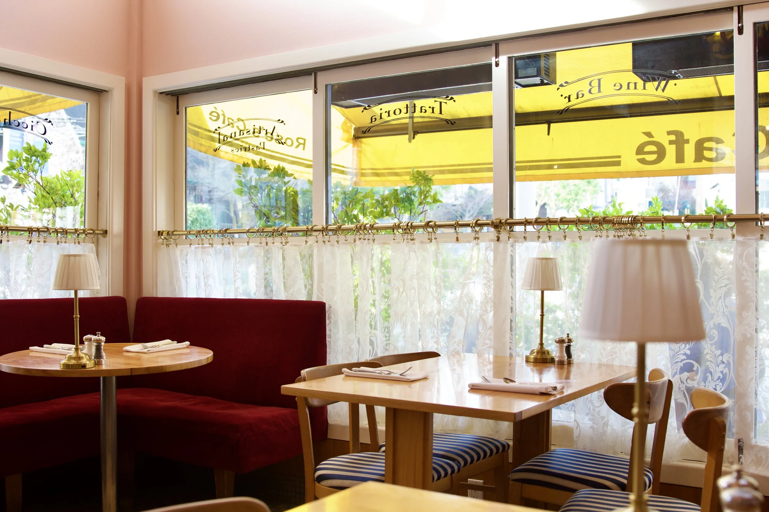 Inside of the cafe with a 4 person table and a red velvet corner booth
