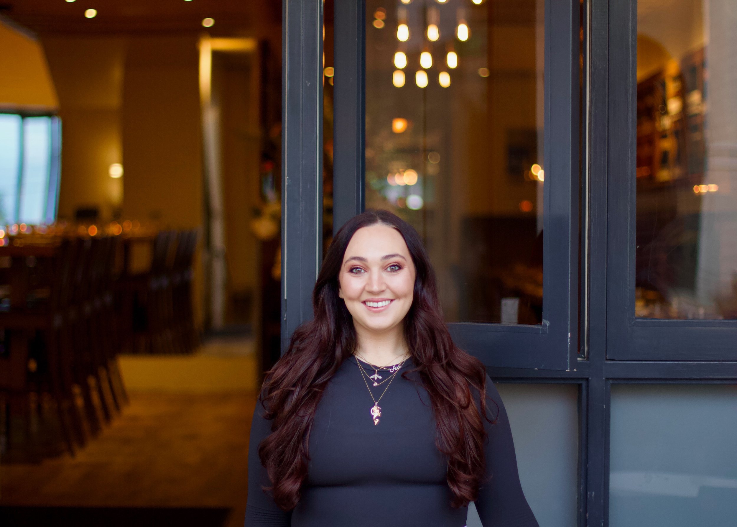Rose's Cafe owner, Ava Rosemary Nicolai smiling in front of the restaurant