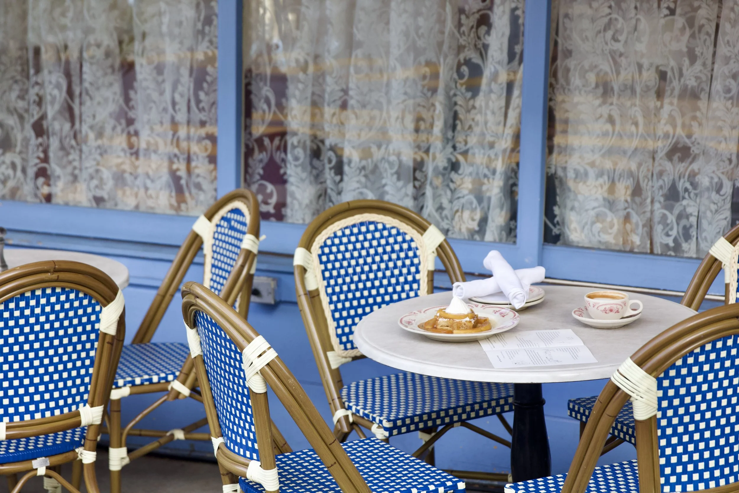 White an blue french bistro chairs on the patio with french toast on the bistro table