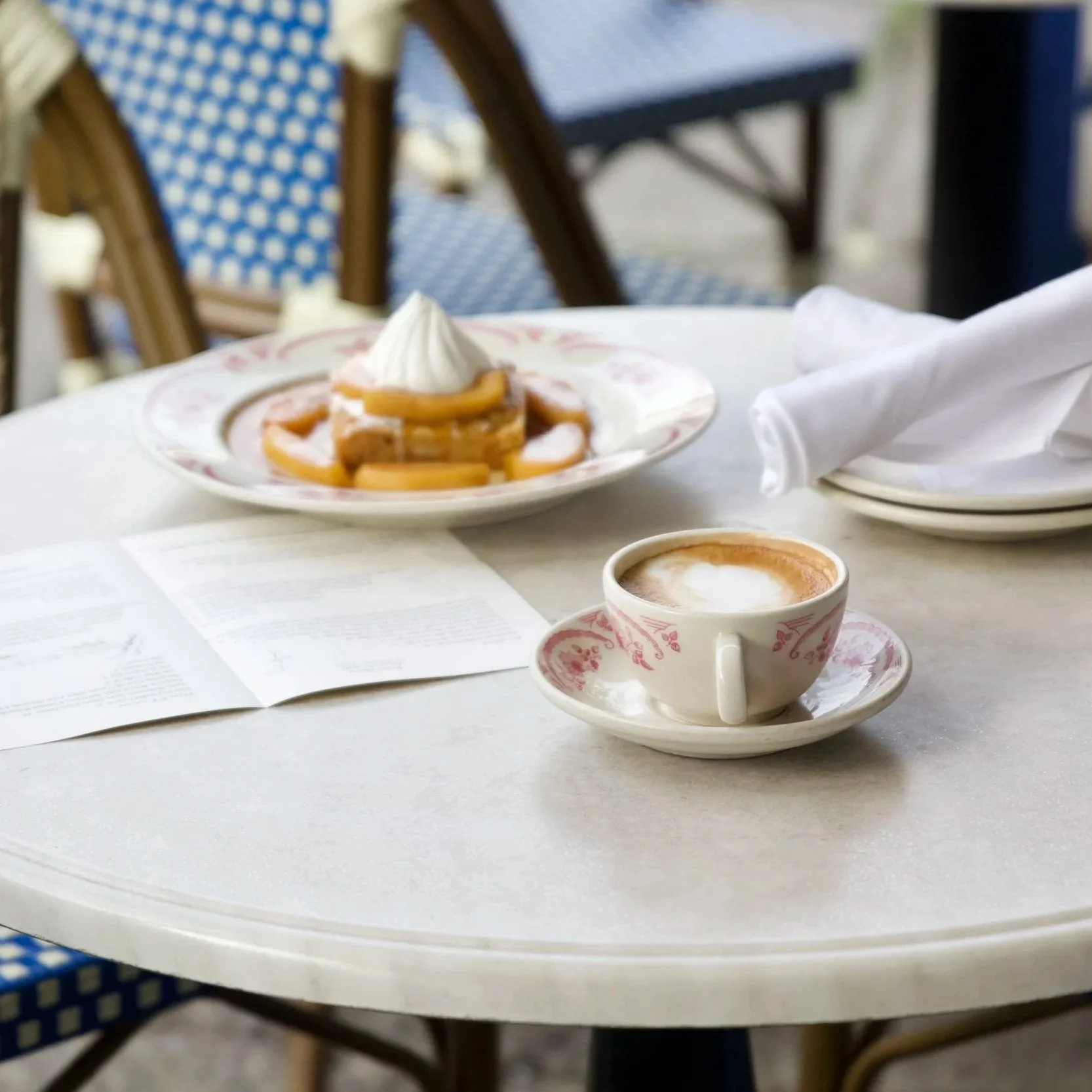 A close-up shot of a latte and french toast on Rose's Cafe's bistro patio seating