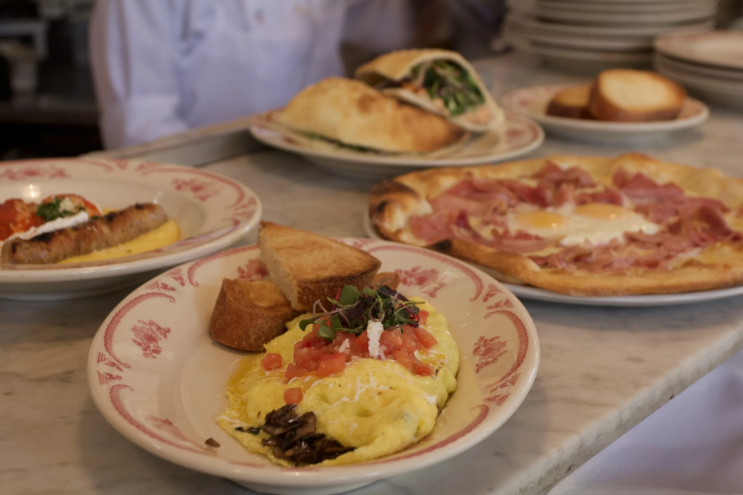 A variety of brunch offerings including and omelette and a breakfast pizza