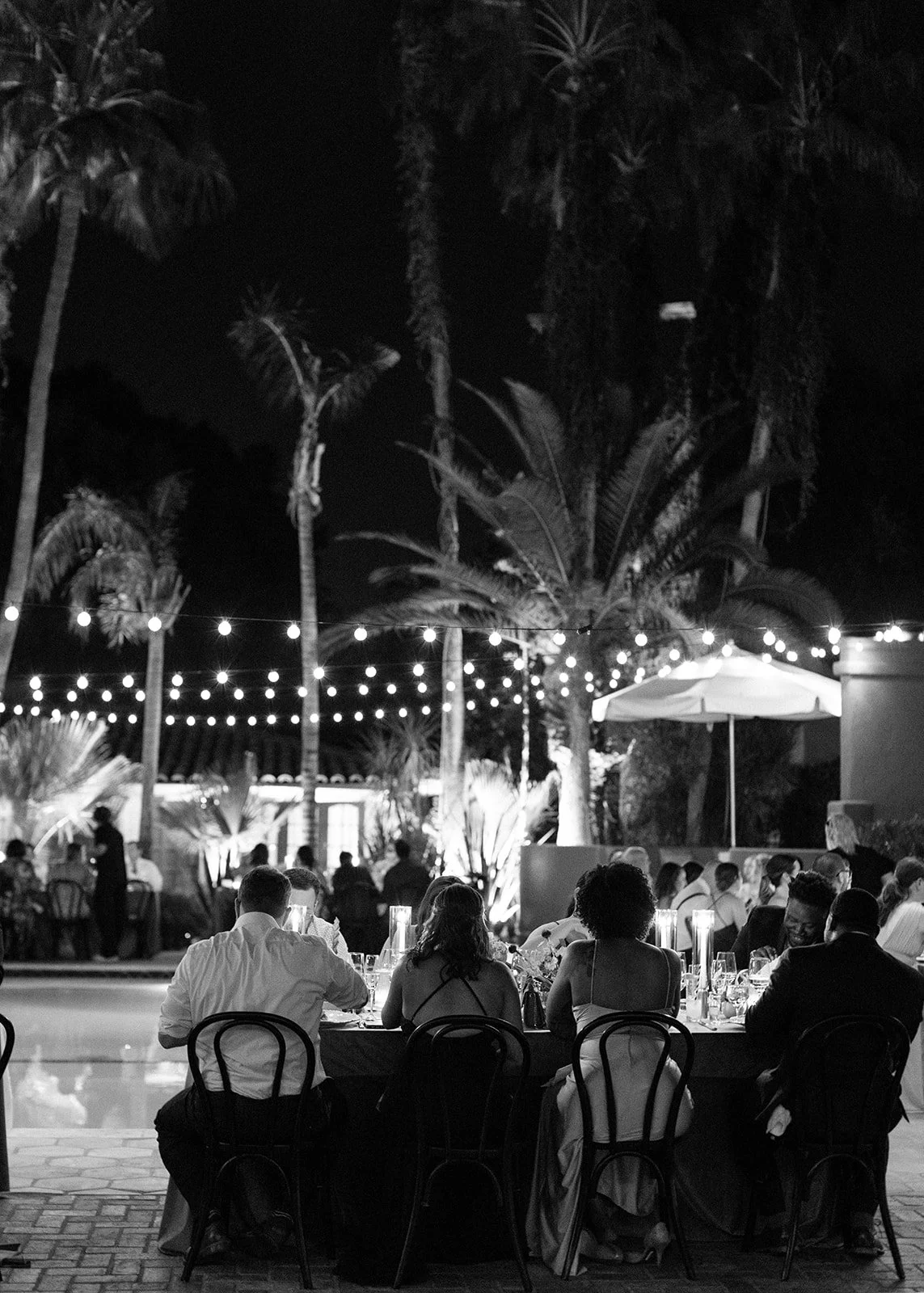 Outdoor wedding reception with candlelit tables and evening ambiance.