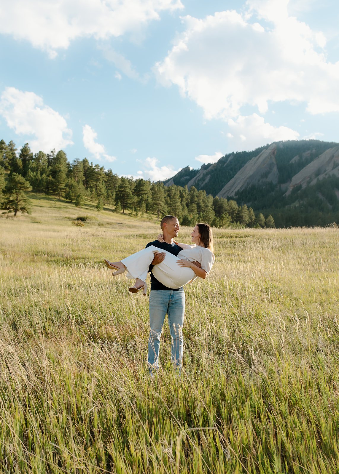 Couple embracing in natural greenery during outdoor portrait.