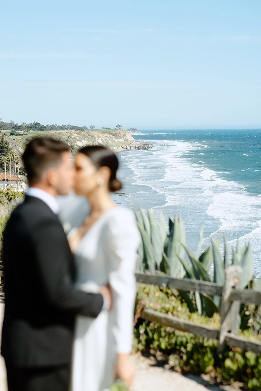 Bride and groom embracing during outdoor wedding.