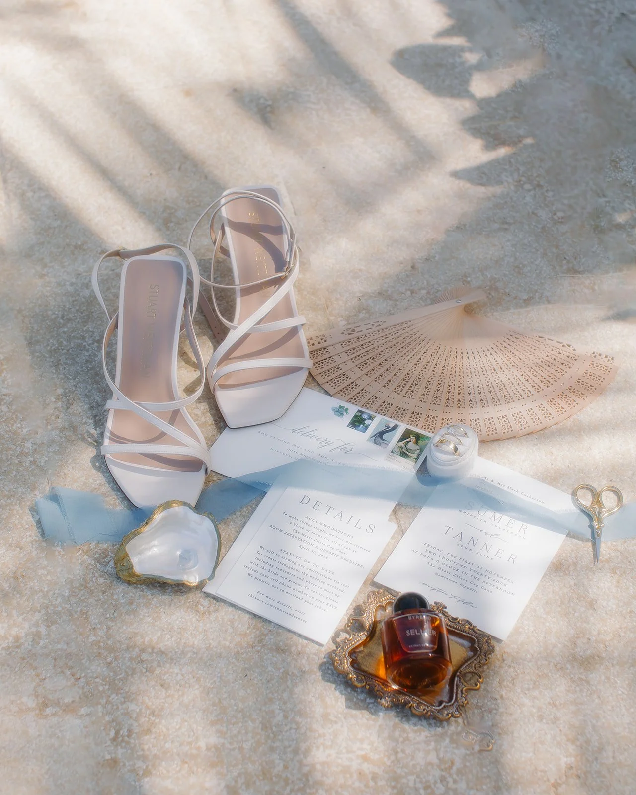 Beach wedding flat lay photo including beach inspired details.