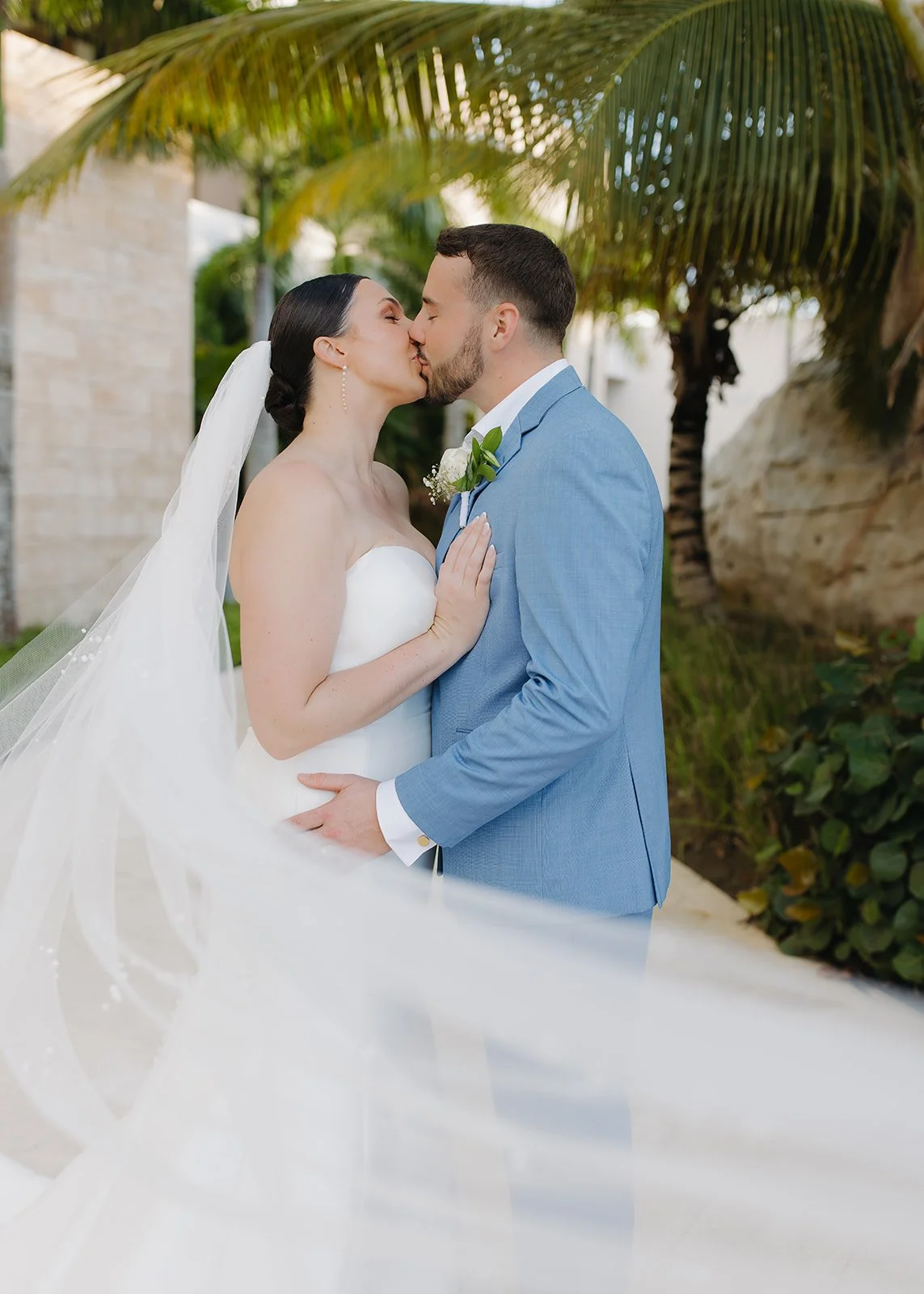 Veil moment while bride and groom share a kiss.
