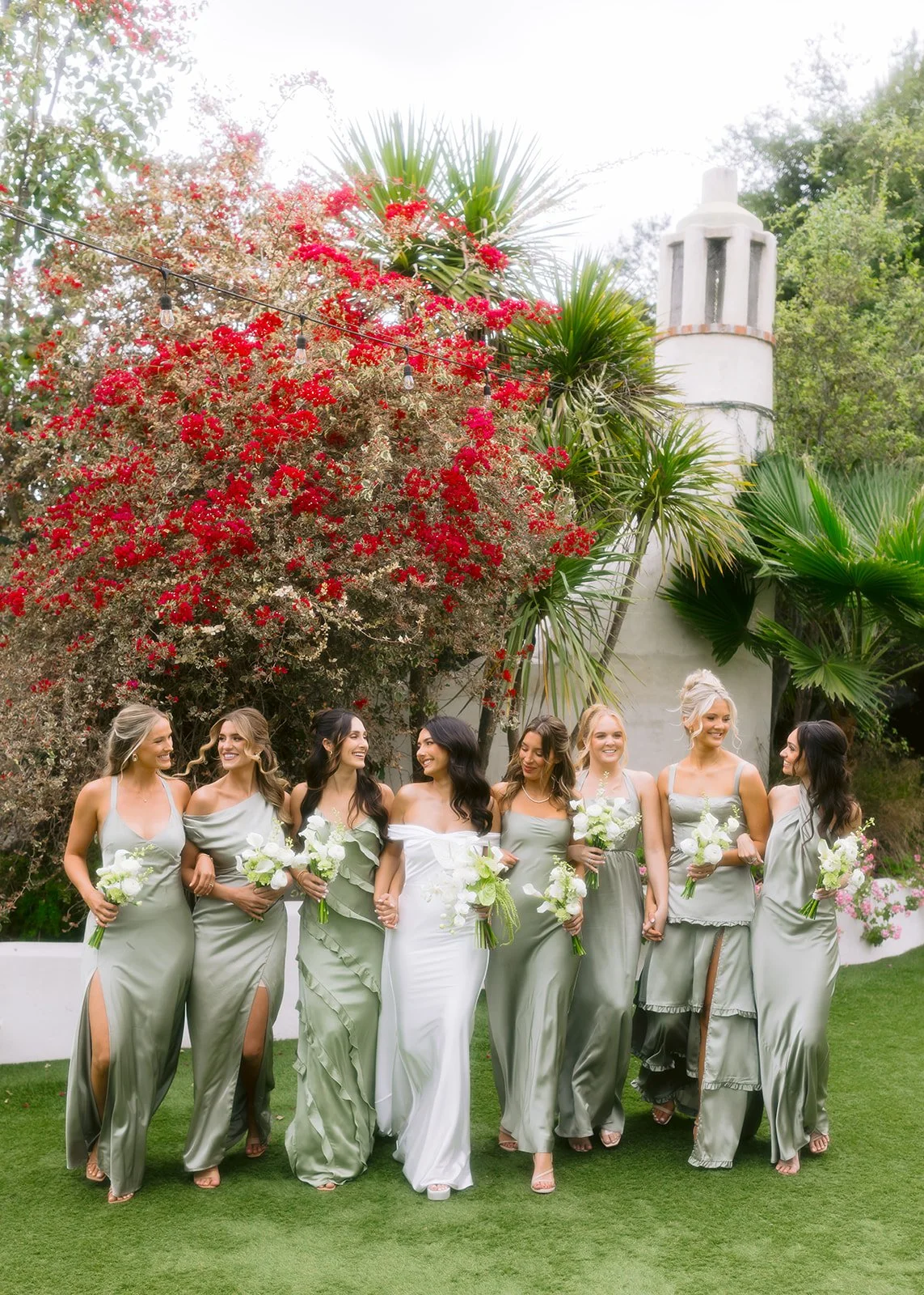 Bride and bridesmaid walking together during outdoor wedding portrait.