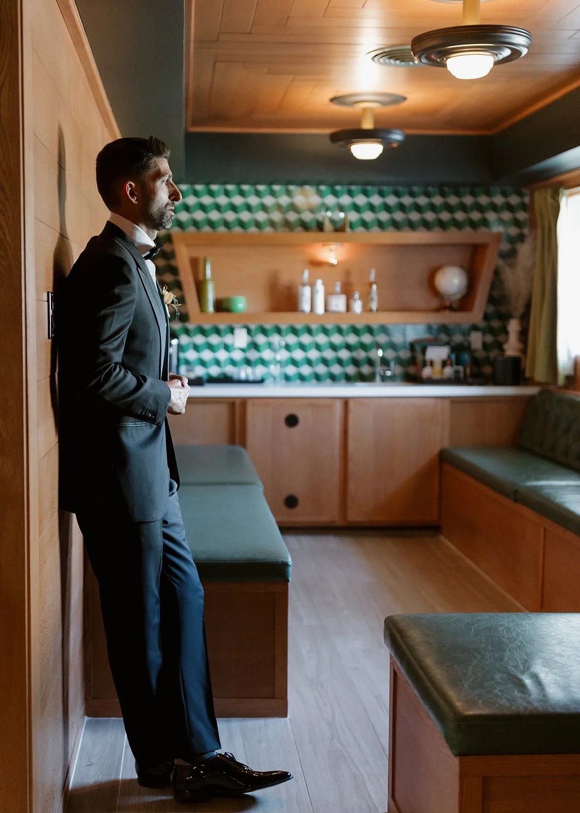 Moody photograph of groom getting ready.