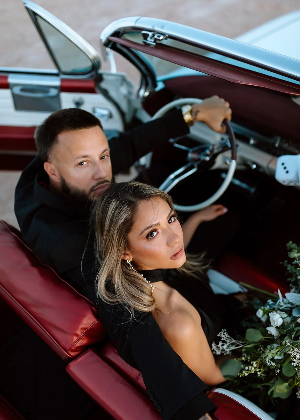Couple posed in vintage car at engagement photoshoot.
