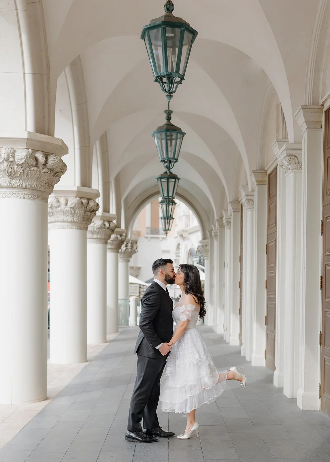 Architectural engagement portrait framed by clean structural lines.