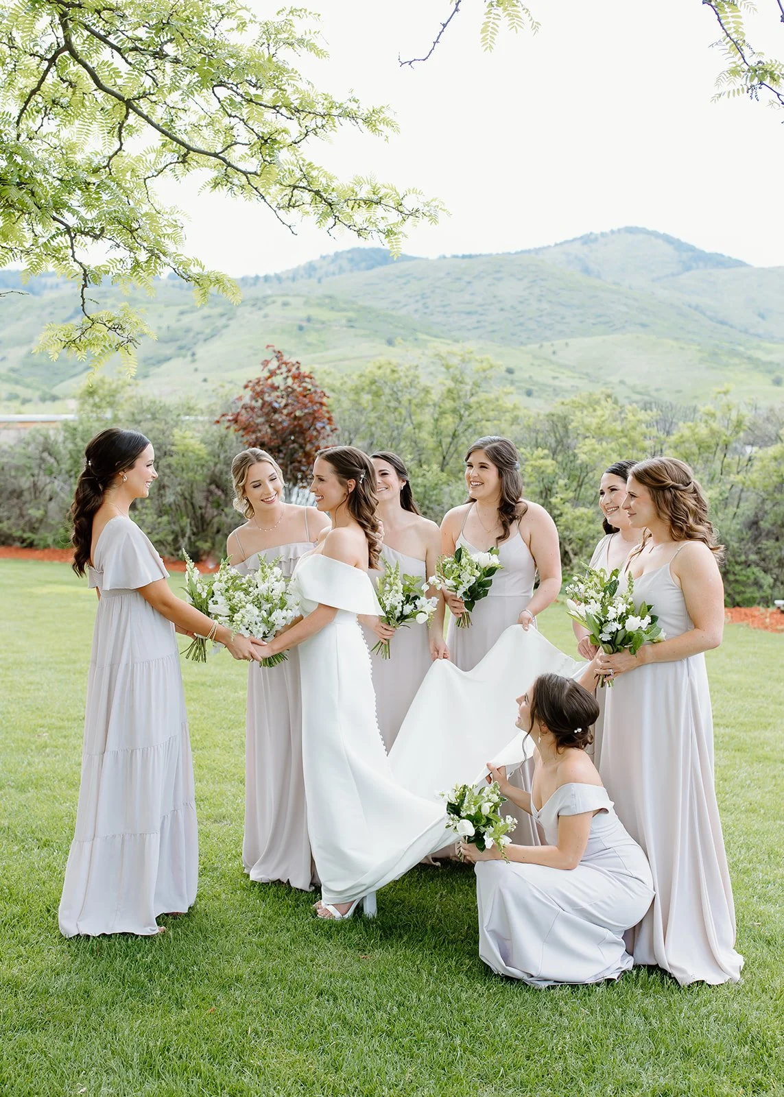 Bridesmaids helping the bride with her dress.