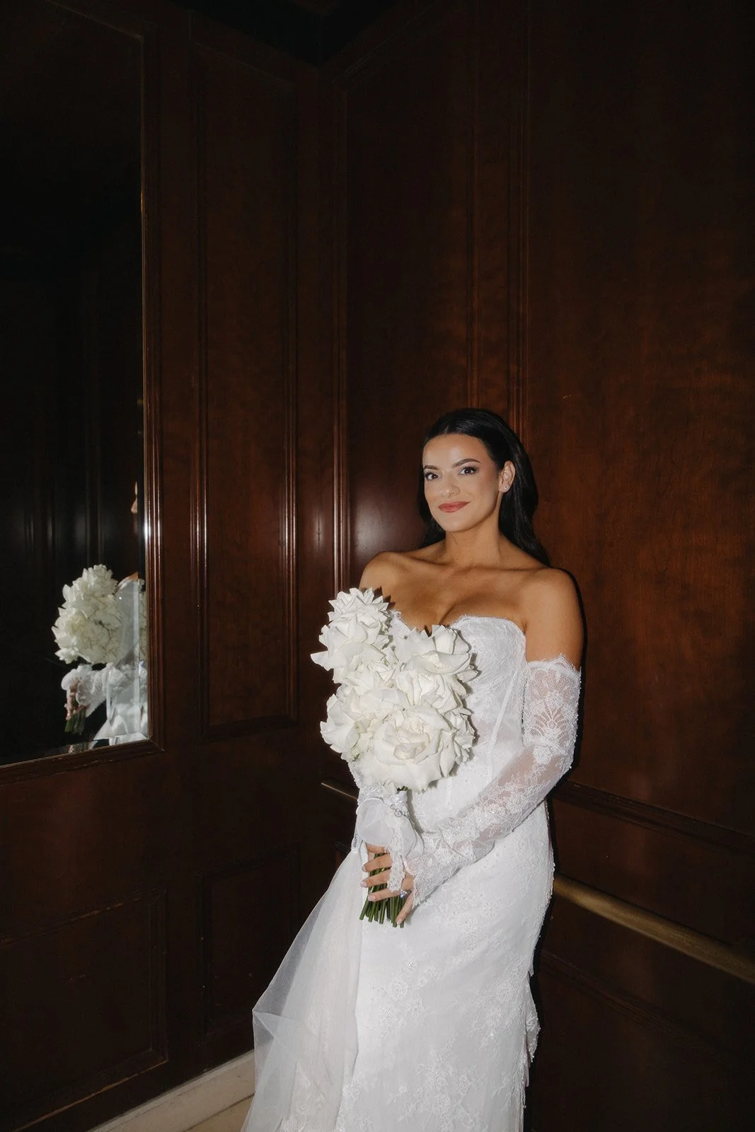 Bride poses for a portrait in the elevator at this black tie wedding.