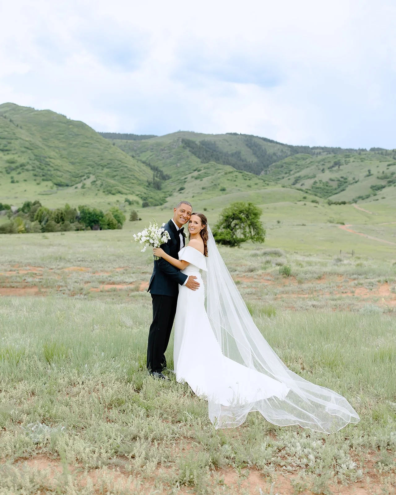 Artfully composed image of bride & groom among greenery.