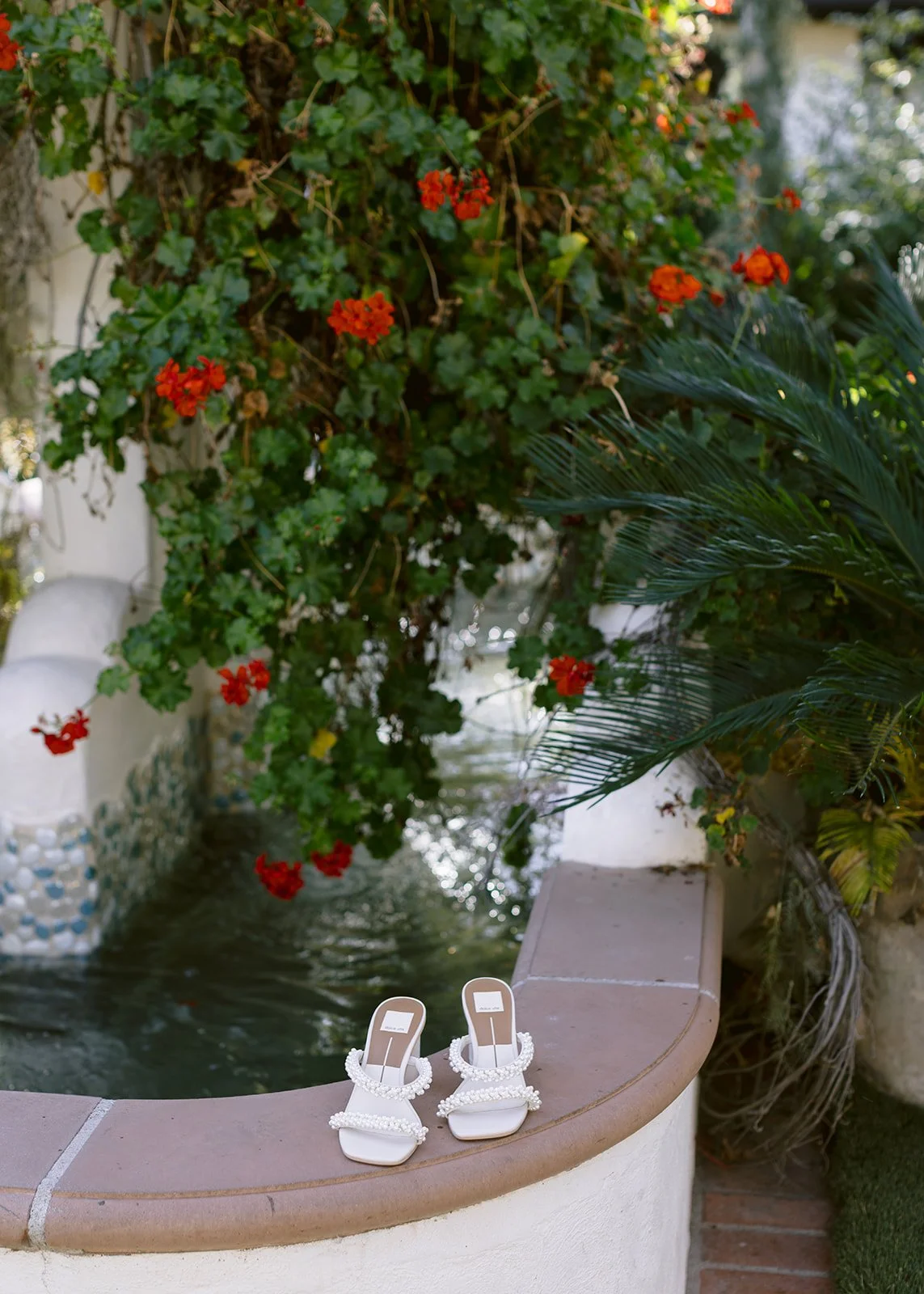 Bridal shoe detail styled outdoors in floral landscape.