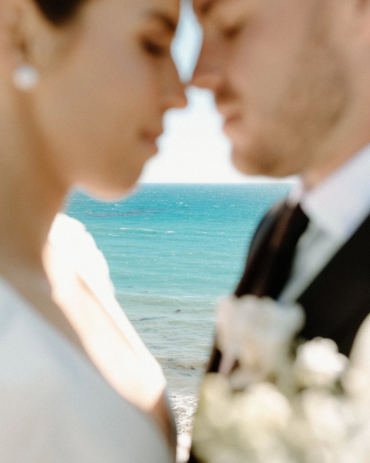 Beach wedding portraits of the couple sharing a romantic moment.