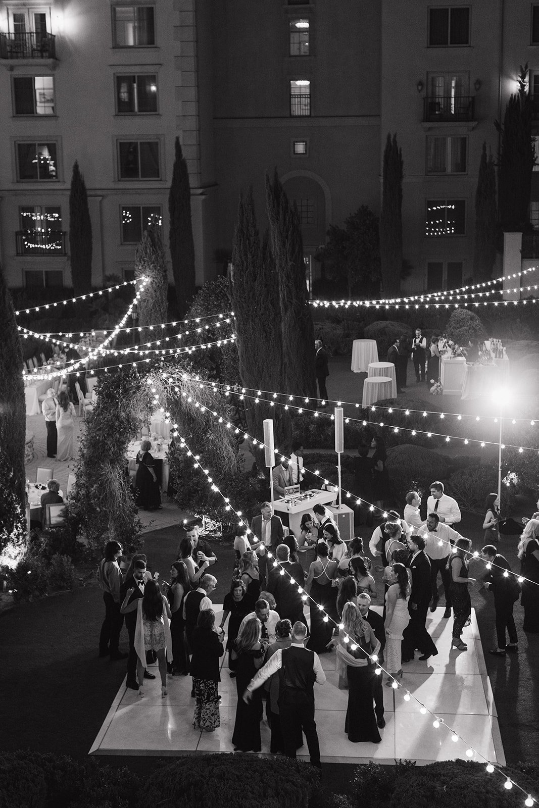 String lit dance floor at garden party reception.