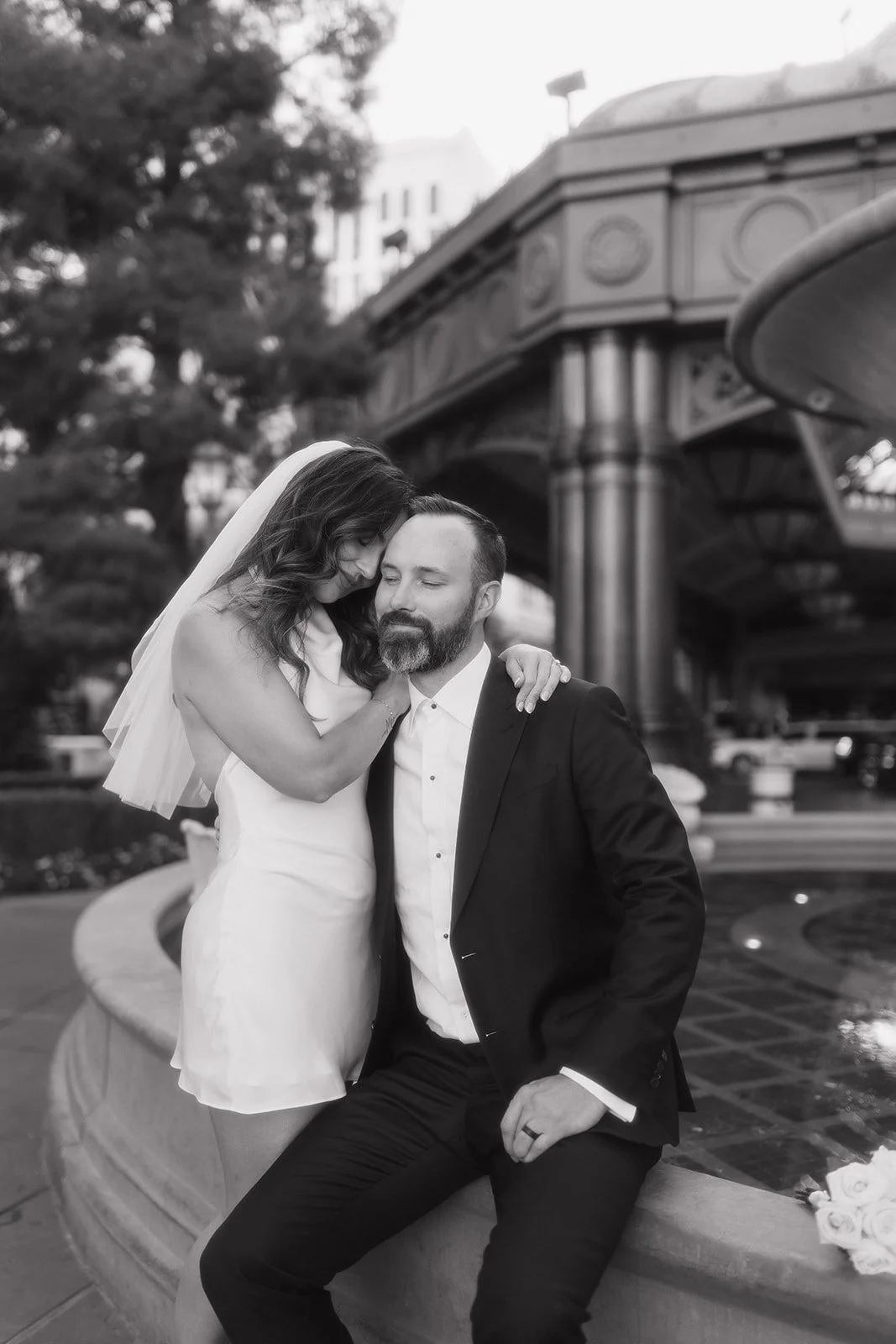Couple posed in urban setting during modern engagement portrait.