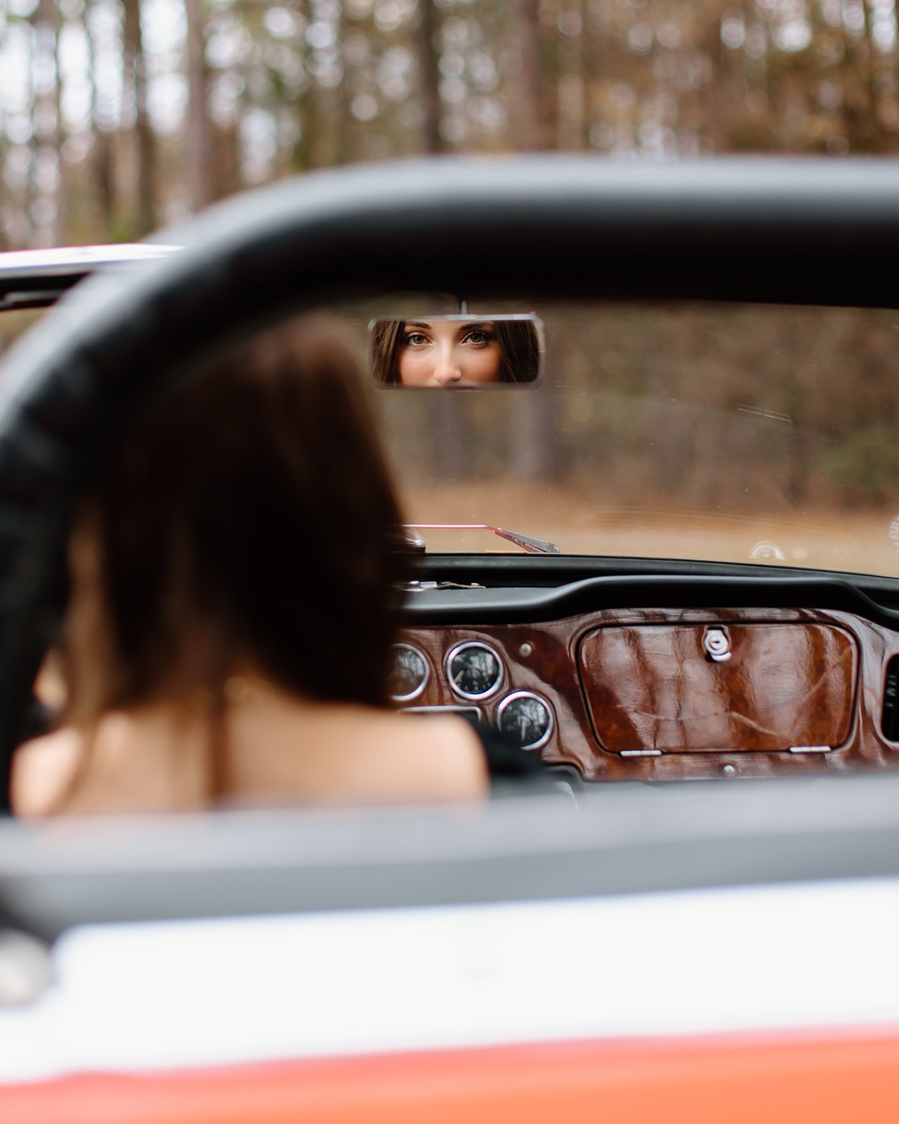 Senior portrait in open setting with vintage car detail.