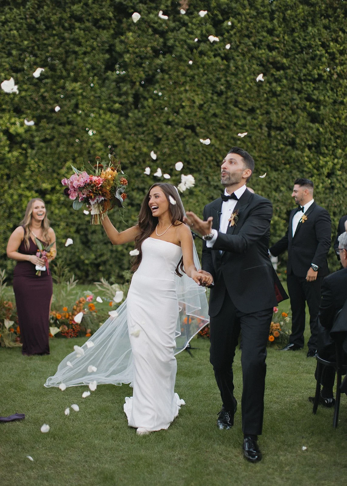 Bride and groom celebrating together while walking down the wedding aisle.