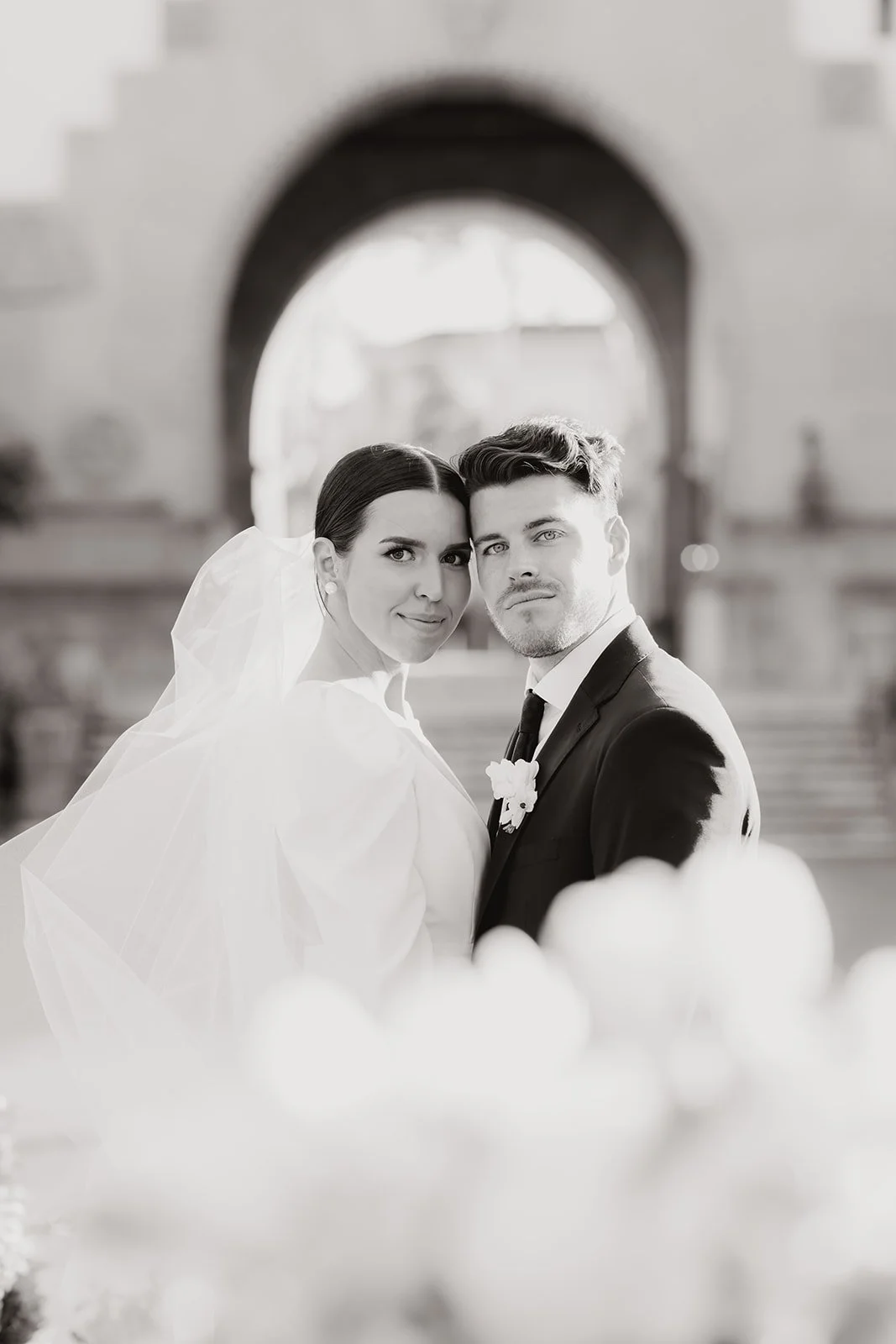 Bride and groom portrait captured under an archway.