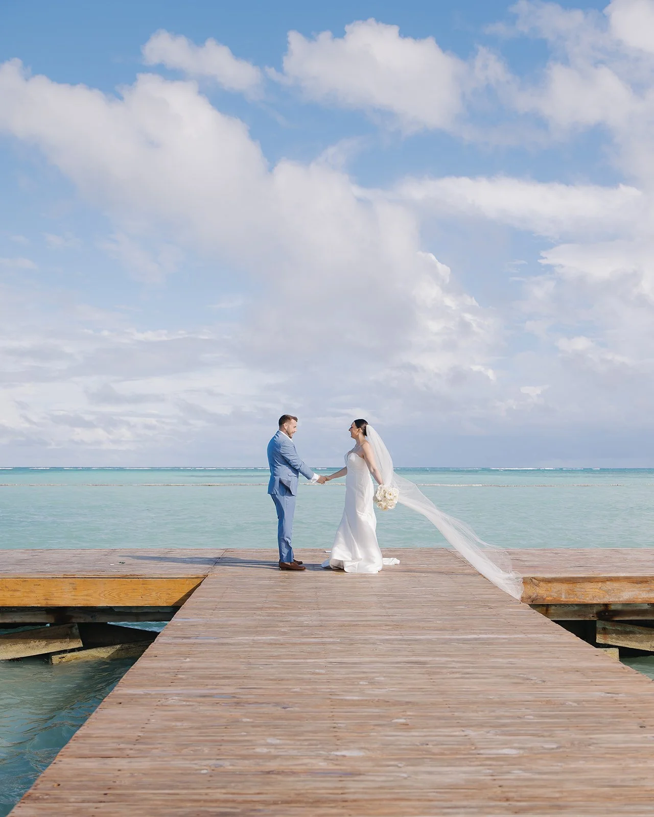 Beachfront wedding portrait as bride and groom share a happy moment.