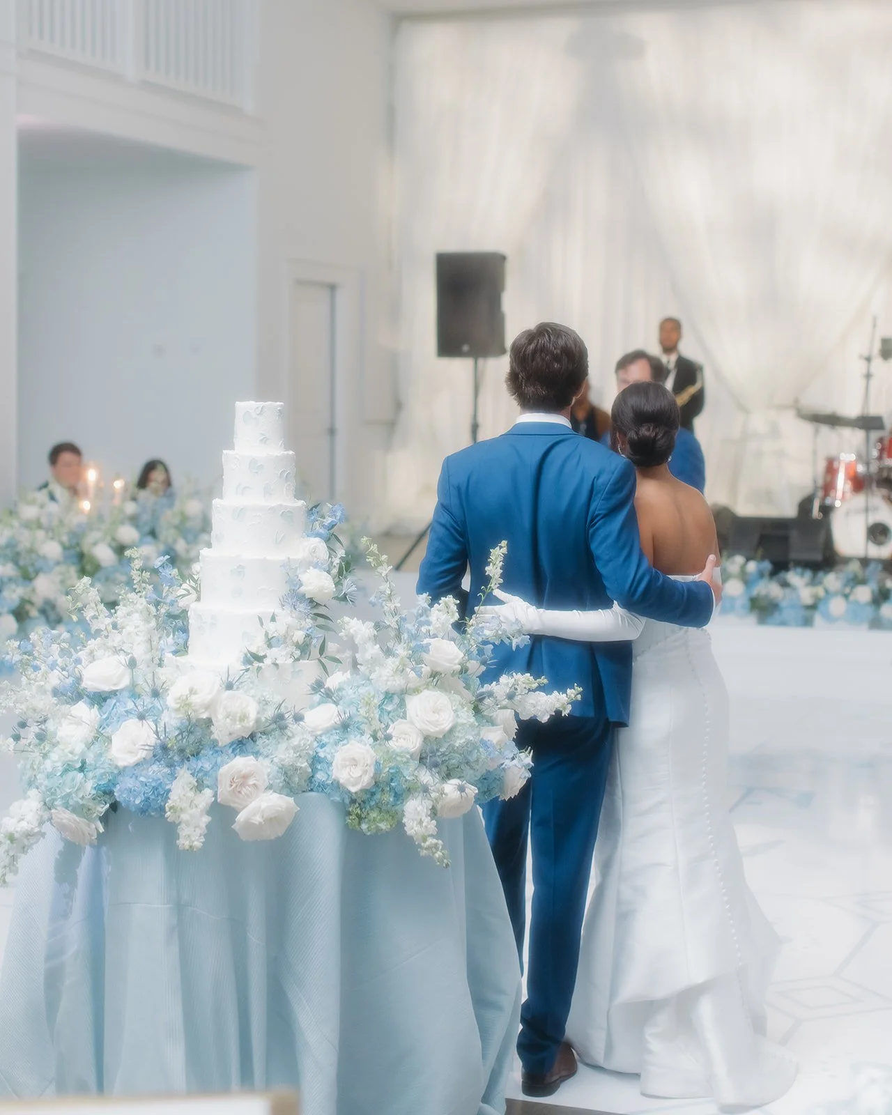 Bride and groom embrace during speeches.