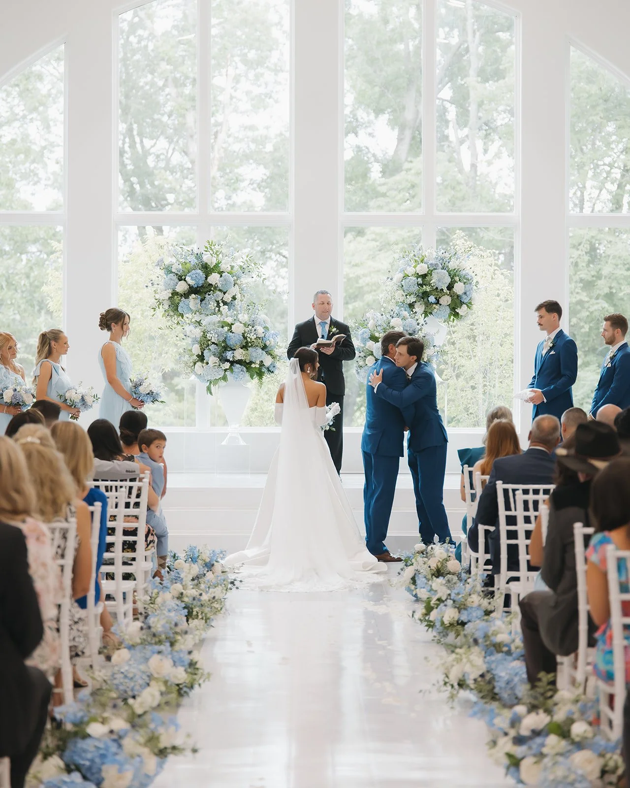 Father of the bride gives the bride away and hugs the groom during ceremony.