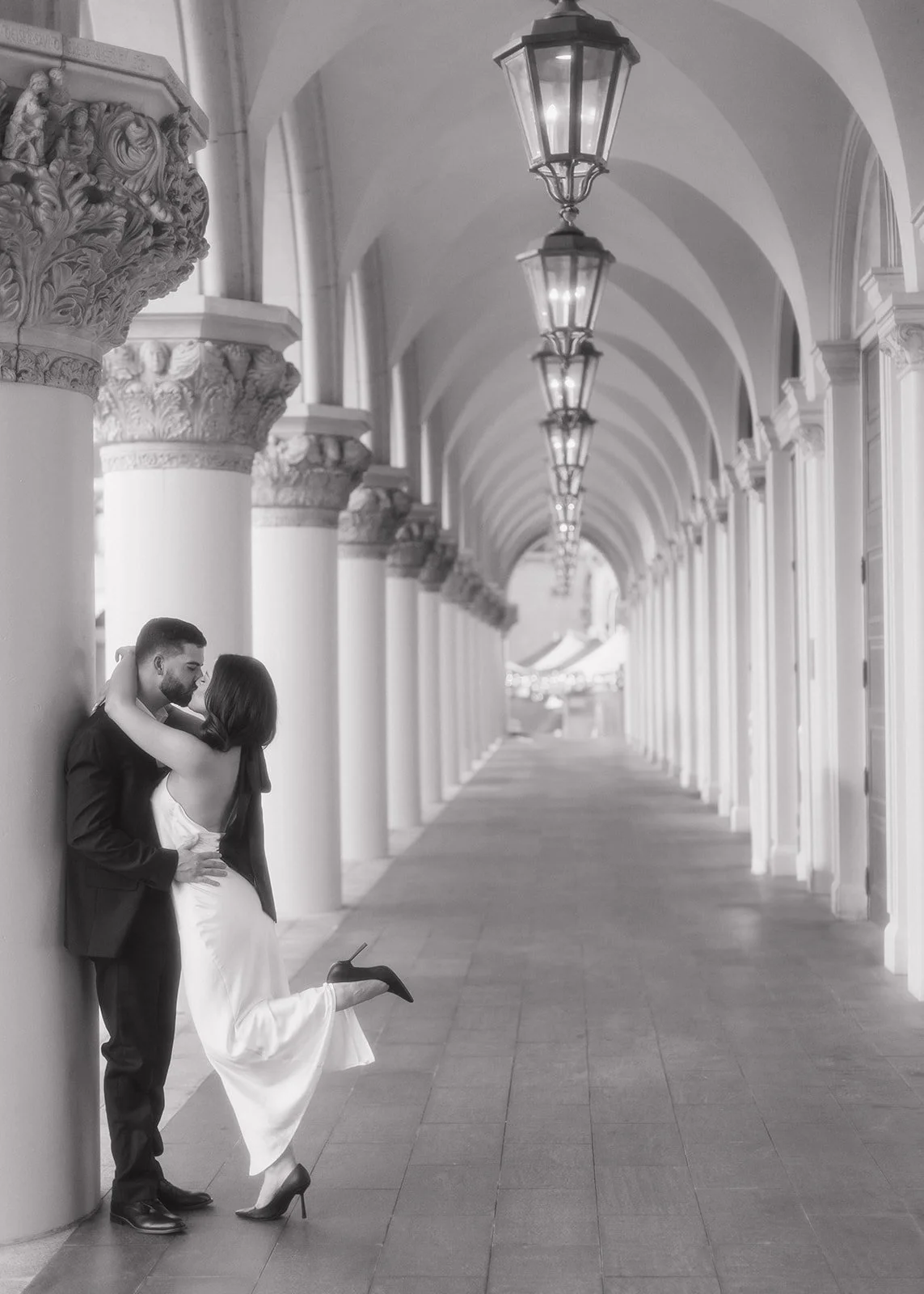 Refined engagement portrait of couple posed in formal setting.