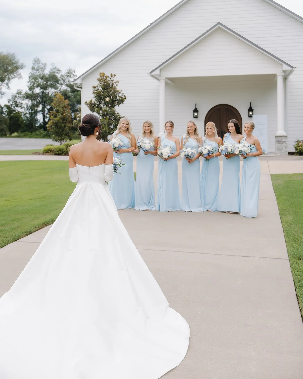 Bridesmaids have a moment with the bride at coastal wedding venue.