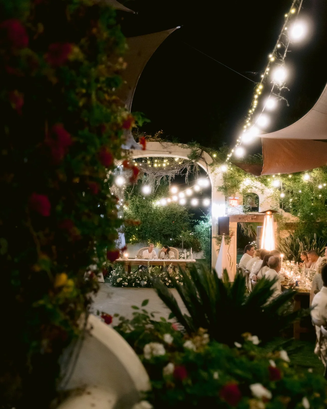 Photo of outdoor wedding reception at night with ambient lighting.