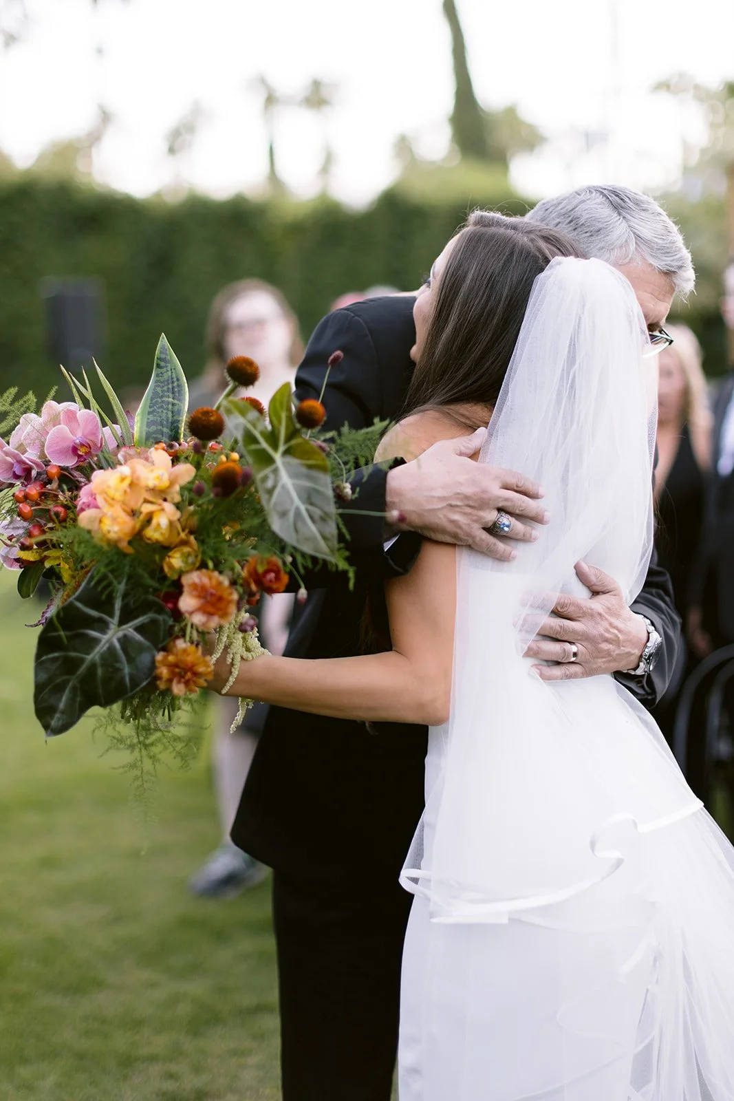 Bride and father of the bride share a hug after walking down the aisle.