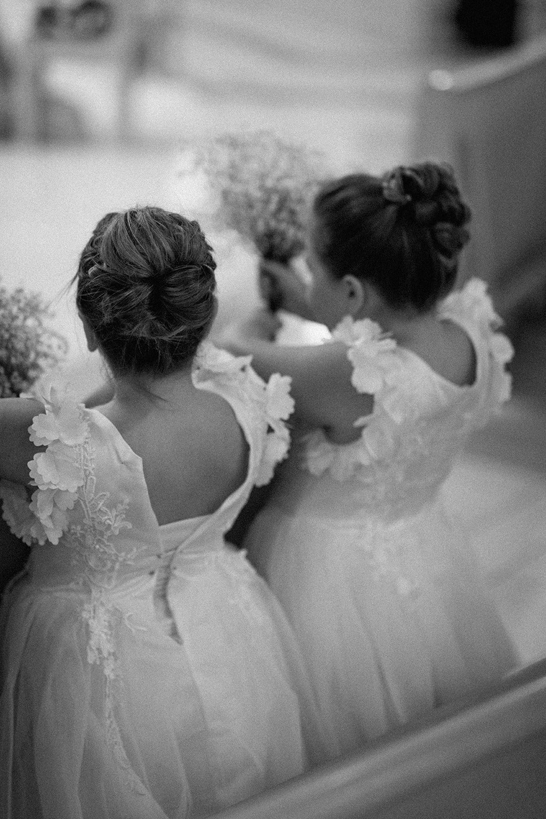 The flower girls sitting and watching the wedding ceremony.