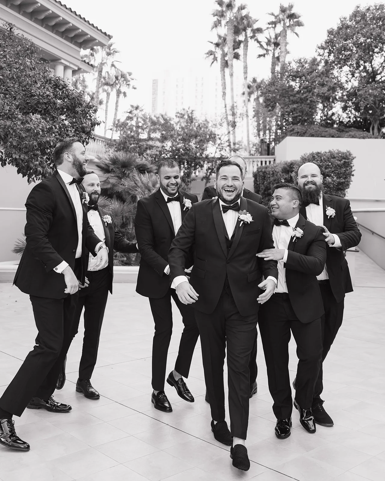 Groomsmen enjoying a laugh during black tie wedding.