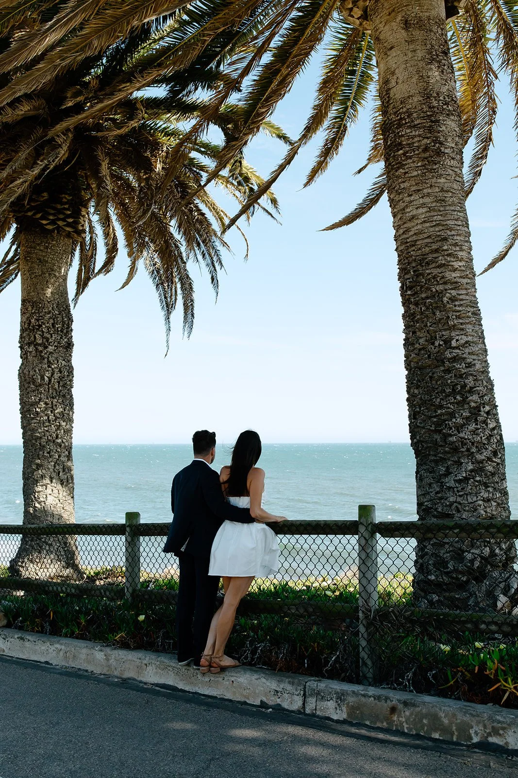 Engagement photos on St. Augustine Beach featuring a couple with expansive shoreline, dunes, and ocean views.