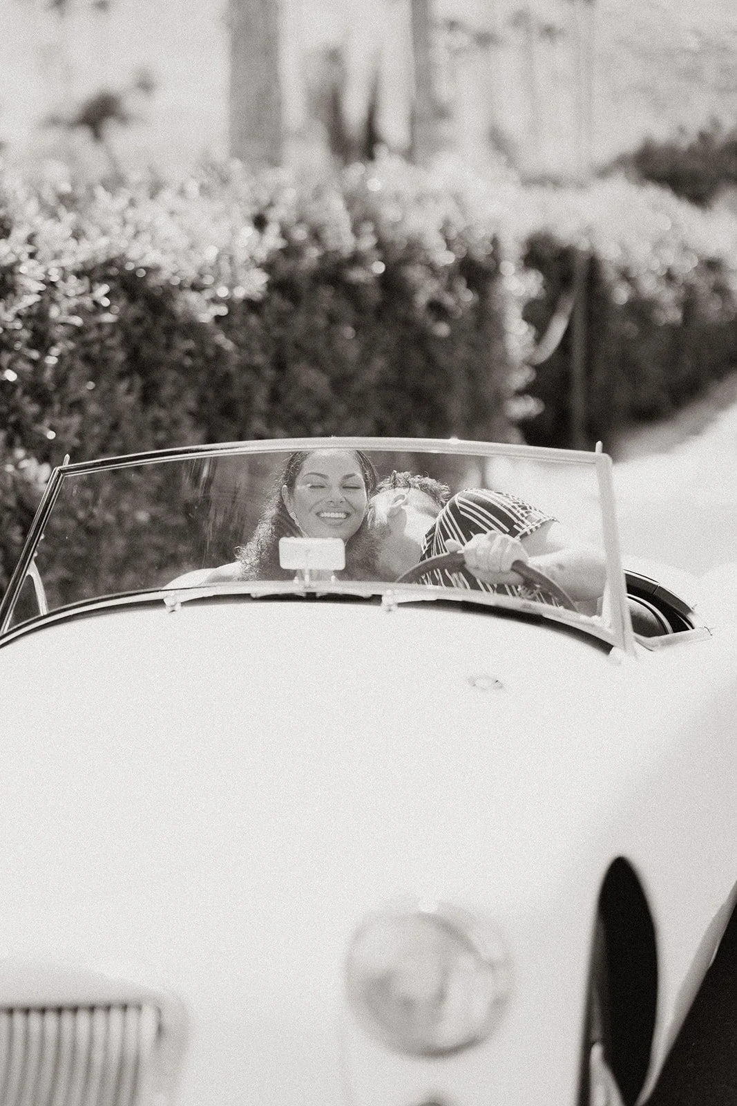 Couple posed with classic car during styled engagement session.