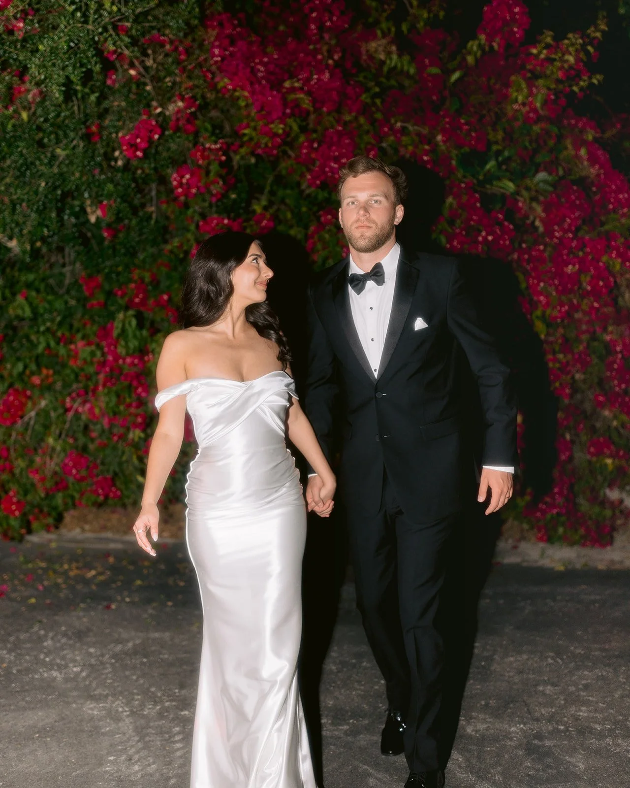 Flash photography shot of the bride & groom in front of bougainvilleas. 