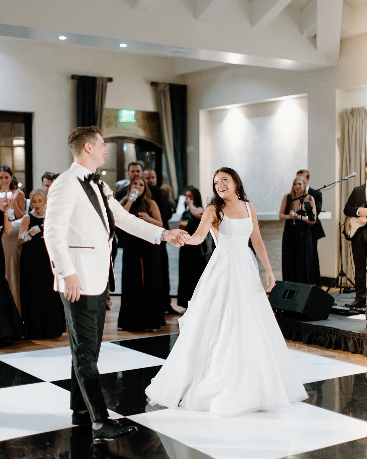Bride and groom share a first dance in an elegant ballroom.