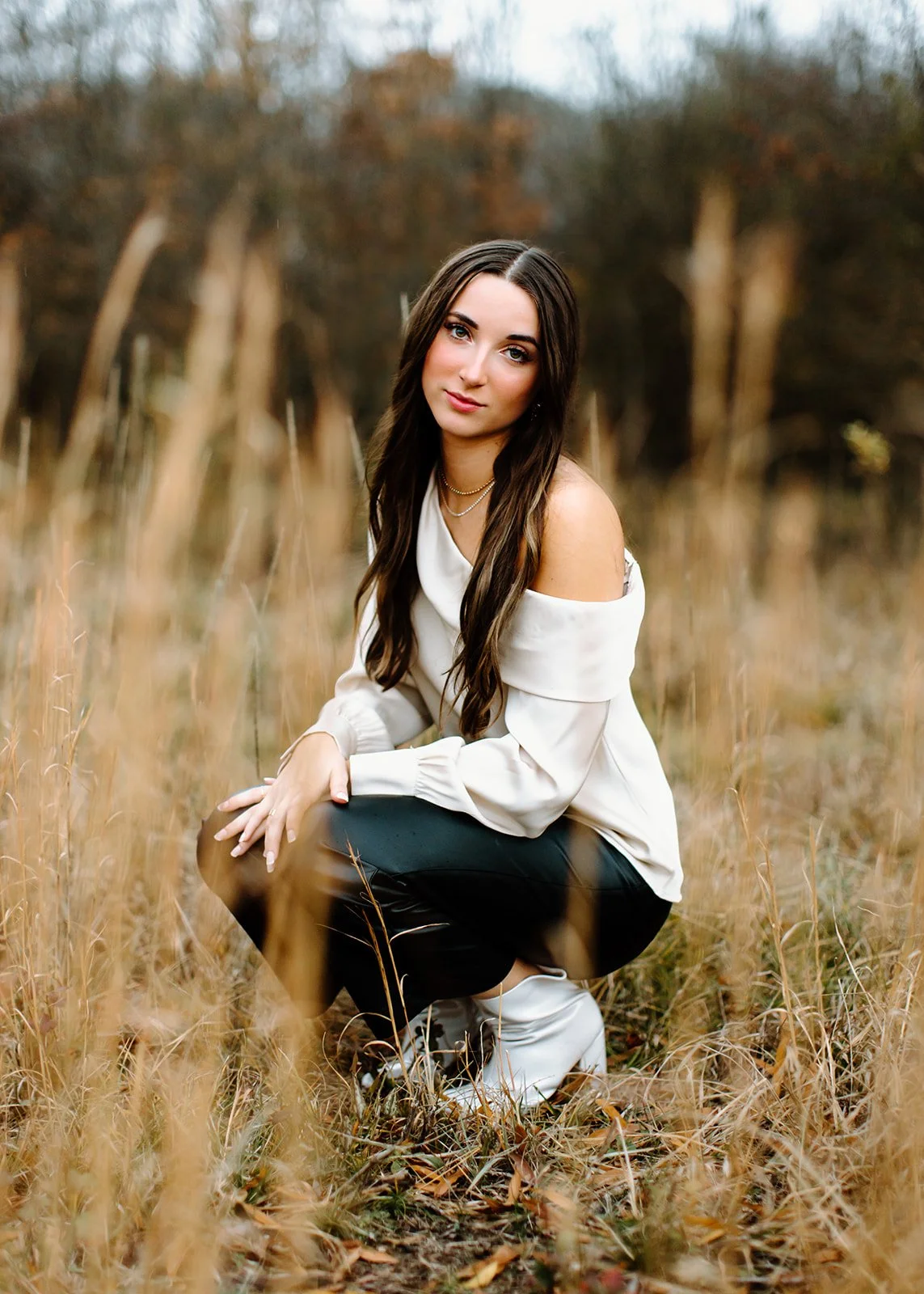 Senior portrait captured outdoors with composed and confident styling.