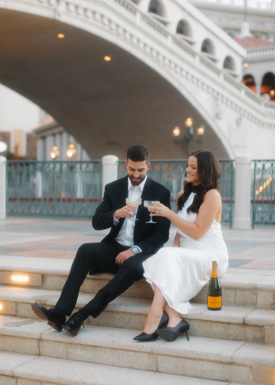 Couple celebrating with champagne during engagement portrait session.