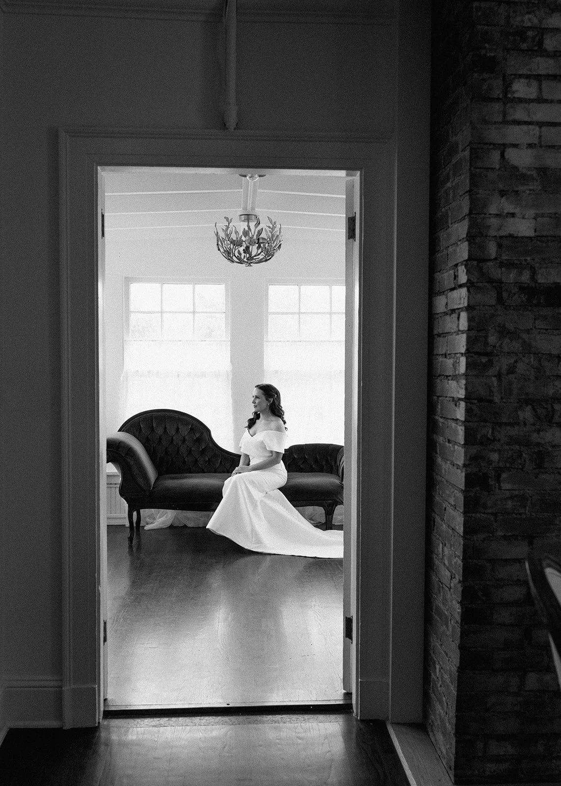 Bride perfectly framed in doorway as she prepares for wedding ceremony.