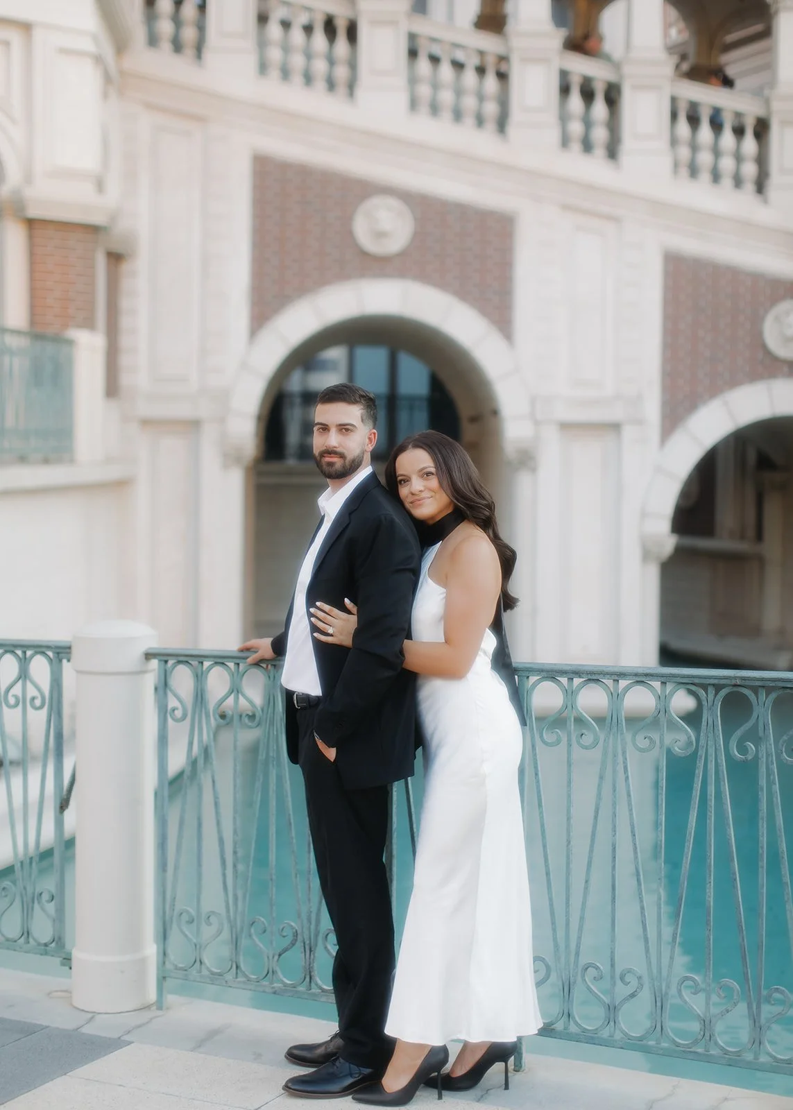 Couple posed under archway during well composed photo.