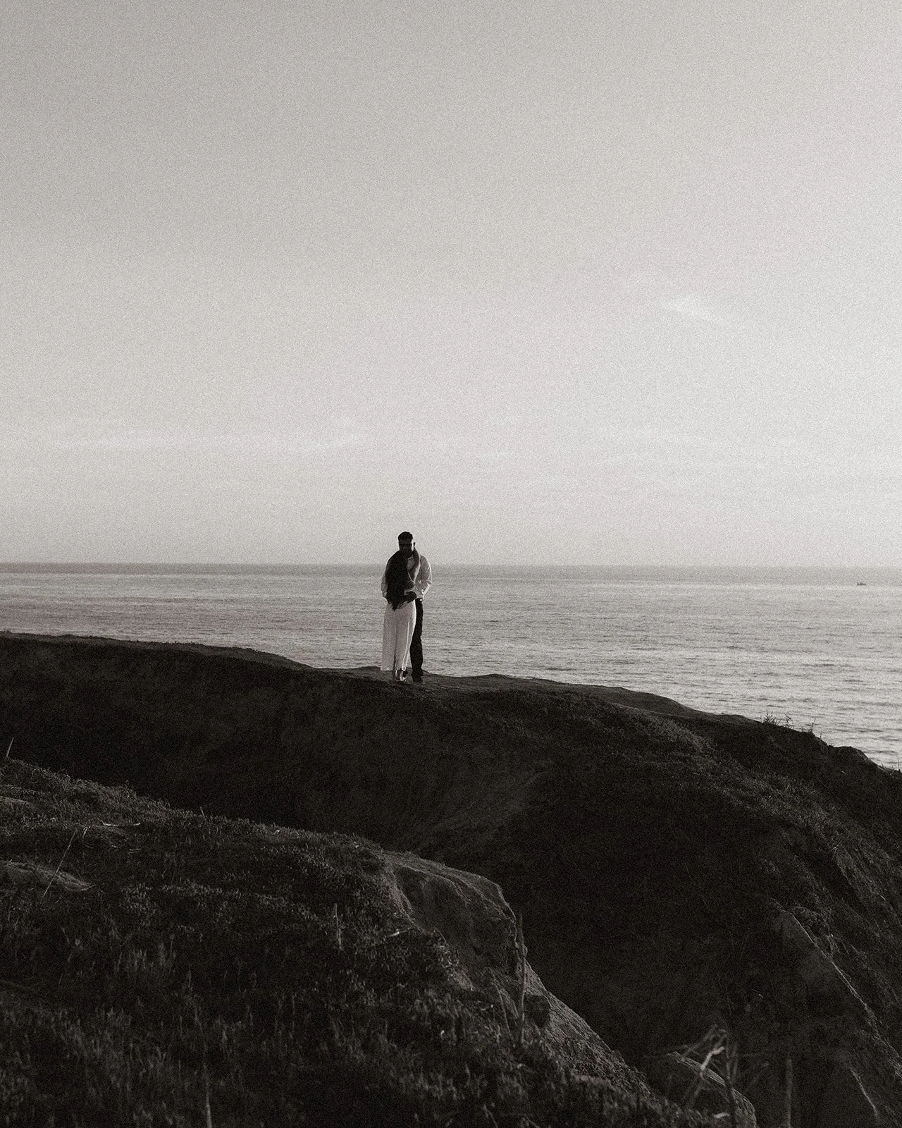 Beachside engagement portrait captured in soft evening light.